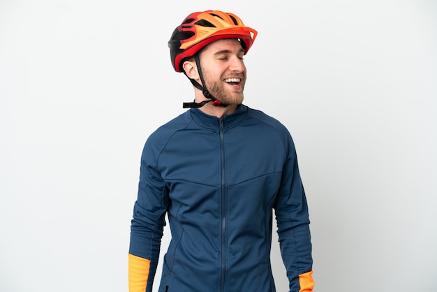 Young cyclist man isolated on white background laughing