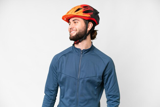 Photo young cyclist man over isolated white background looking side