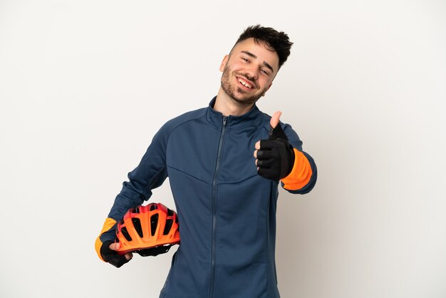 Young cyclist man isolated on white background with thumbs up because something good has happened