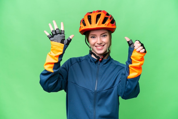 Young cyclist woman over isolated chroma key background counting six with fingers