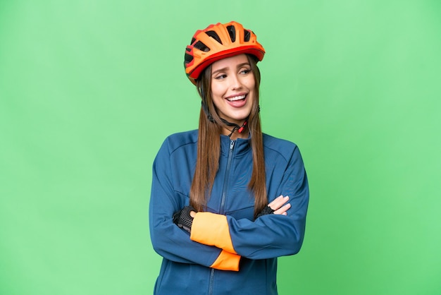 Young cyclist woman over isolated chroma key background happy and smiling