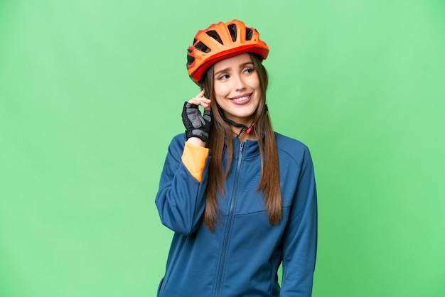 アイデアを考えて分離クロマ キー背景上の若いサイクリストの女性