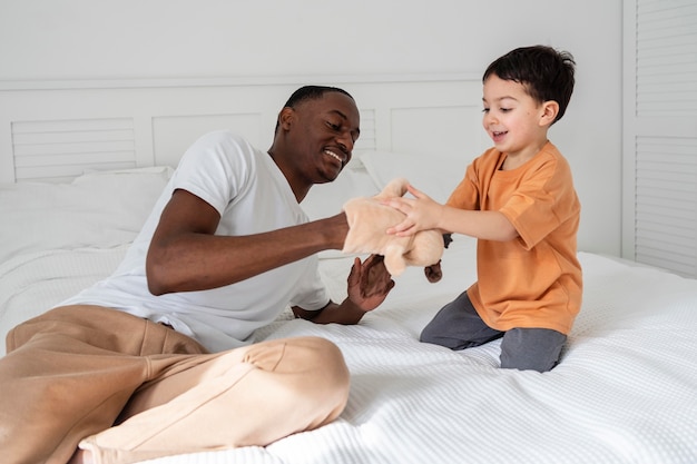 Photo young dad paying with his kid