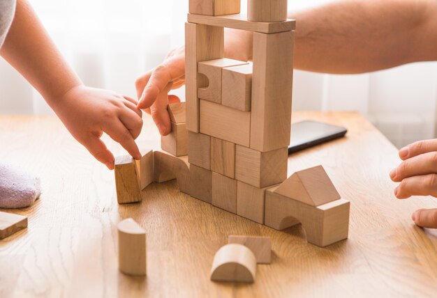 Il giovane papà gioca con i mattoni della costruzione con il figlio piccolo