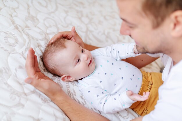 Giovane papà che gioca e parla con suo figlio adorabile