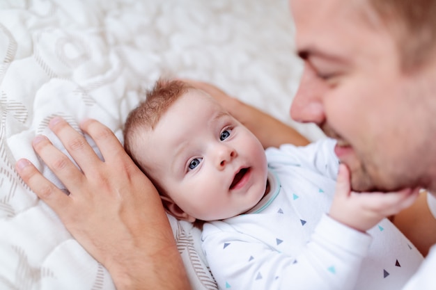 Giovane papà che gioca e parla con suo figlio adorabile