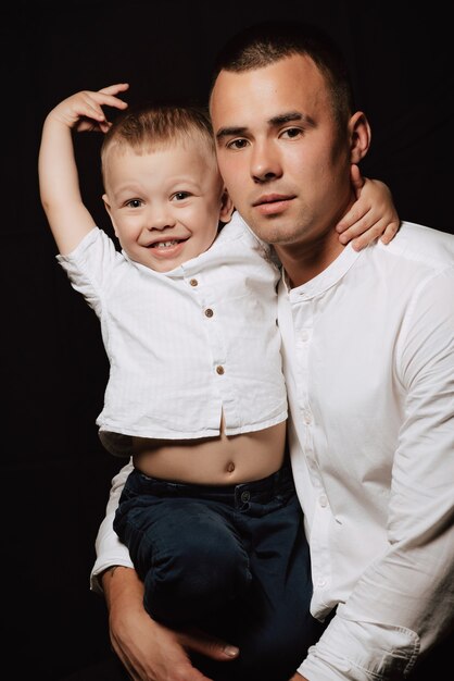 Young dad and son in white shirts posing