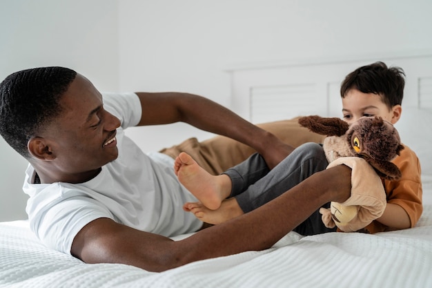 Photo young dad tickled his child while playing