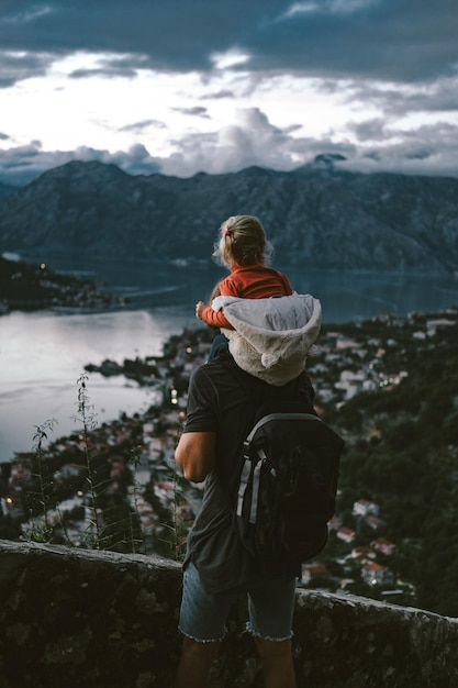 Giovane papà che viaggia con sua figlia nelle montagne del montenegro kotor sera