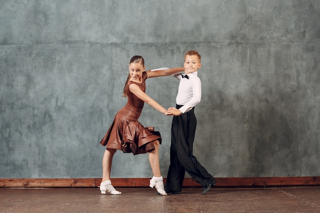 Фото Молодые танцоры мальчик и девочка танцуют в бальных танцах самба.