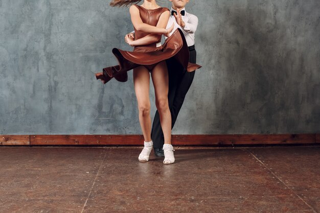 Photo young dancers boy and girl dancing in ballroom dance samba. close up legs.