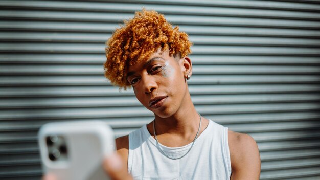 Young darkskinned man posing at the street and taking selfie in the city background man smiling and