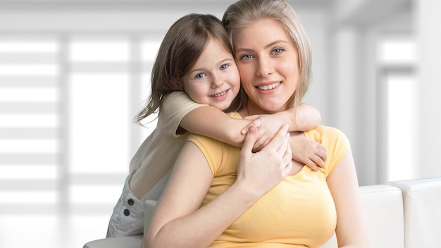 Young daughter closes hands eyes mom - isolated. Happy family people concept.