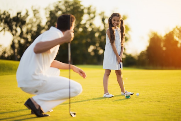 Young Daughter Takes Golf Shot Happy Family.