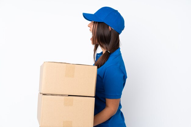 Young delivery brunette girl isolated laughing in lateral position