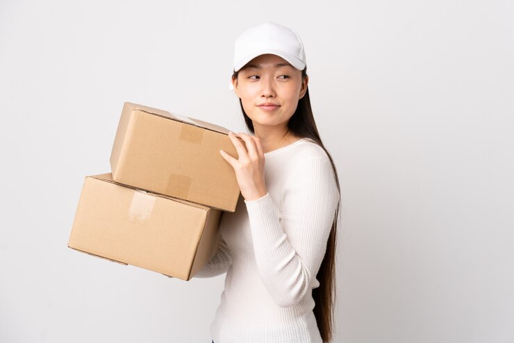 Photo 年輕的中國配送女士在孤立的白色牆上笑