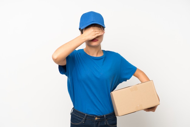 Young delivery girl over isolated white covering eyes by hands