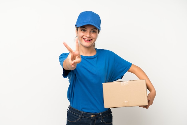 Young delivery girl over isolated white  smiling and showing victory sign