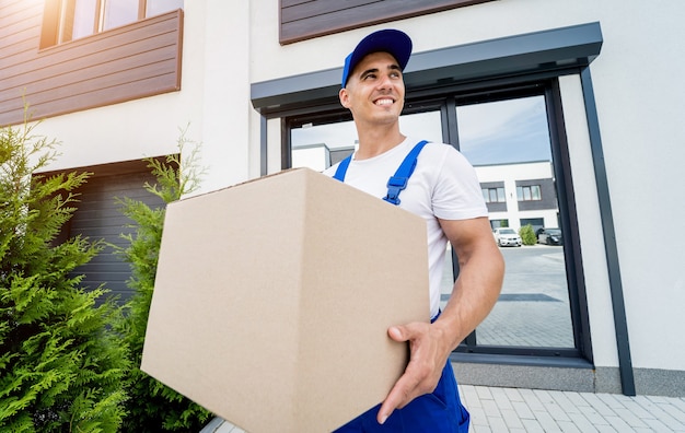 Young delivery man hold a cardboard box in his hands