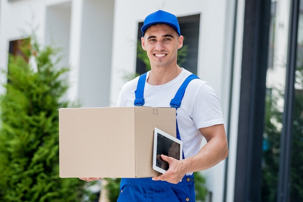 Young delivery man hold a cardboard box in his hands