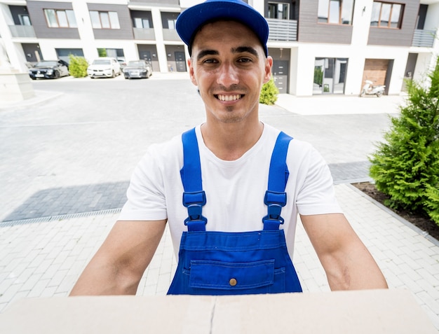 Young delivery man hold a cardboard box in his hands