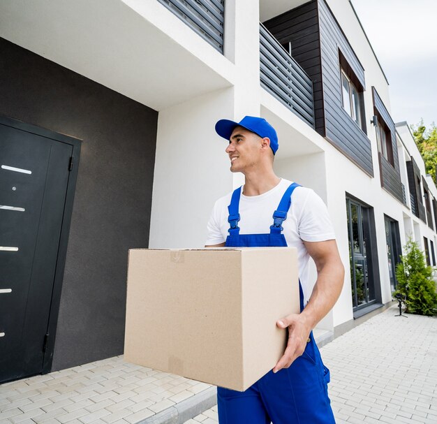 Young delivery man hold a cardboard box in his hands