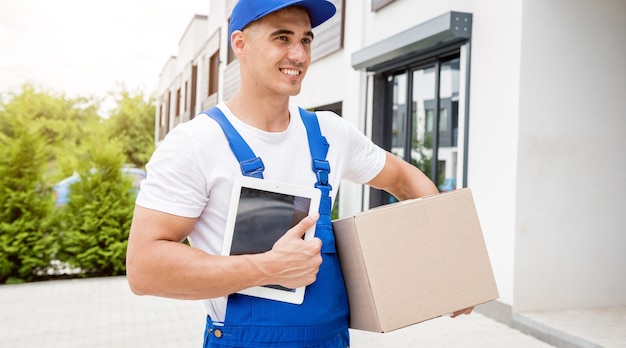 Young delivery man hold a cardboard box in his hands