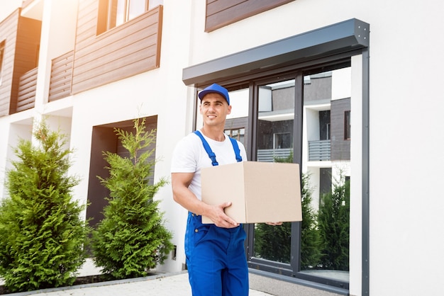 Young delivery man hold a cardboard box in his hands