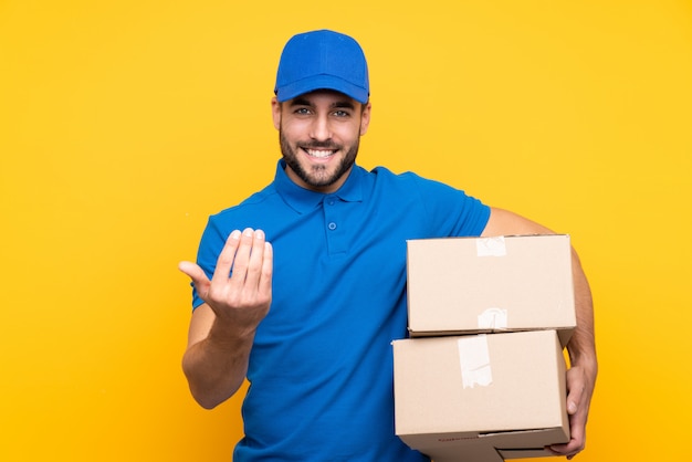 Young delivery man over isolated wall