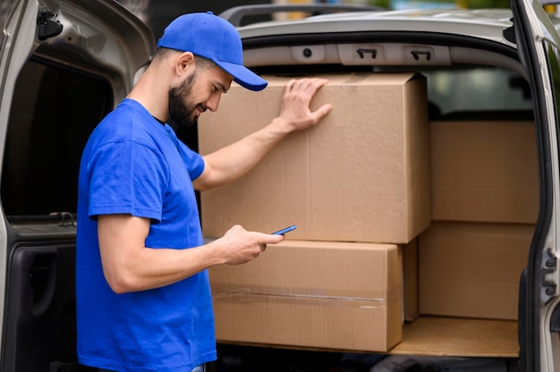 写真 出荷を確認する若い配達人