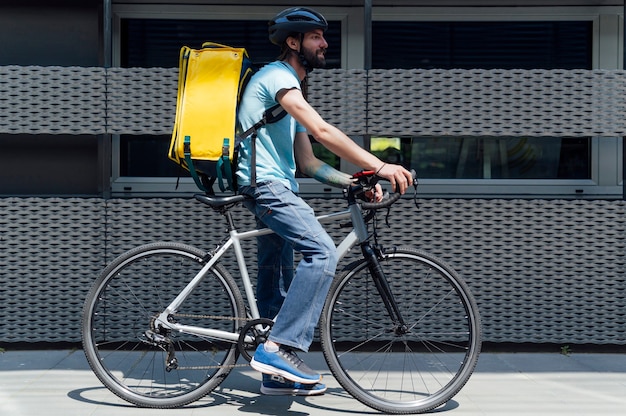 Photo young delivery man with yellow backpack takeaway concept