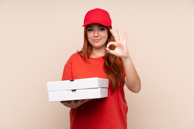 Young delivery woman holding pizzas