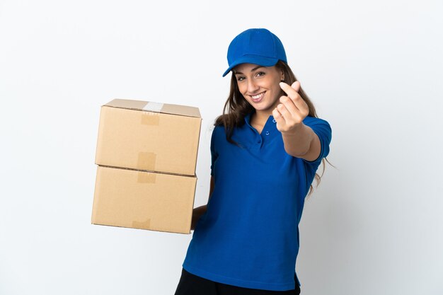 Young delivery woman over isolated white making money gesture