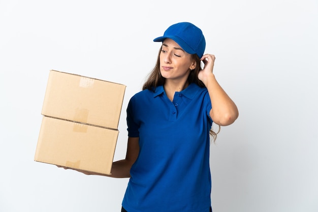 Young delivery woman over isolated white wall having doubts