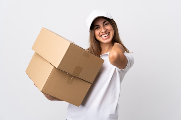 Young delivery woman over isolated white wall laughing