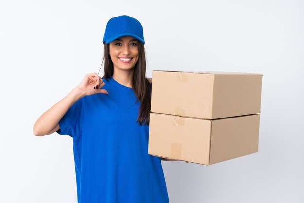 Young delivery woman over isolated white wall proud and self-satisfied