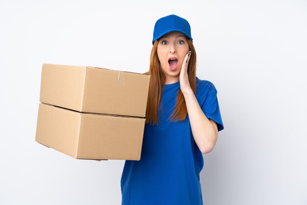 Young delivery woman over isolated white wall with surprise facial expression