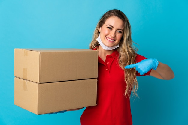 Young delivery woman isolated on white with surprise facial expression