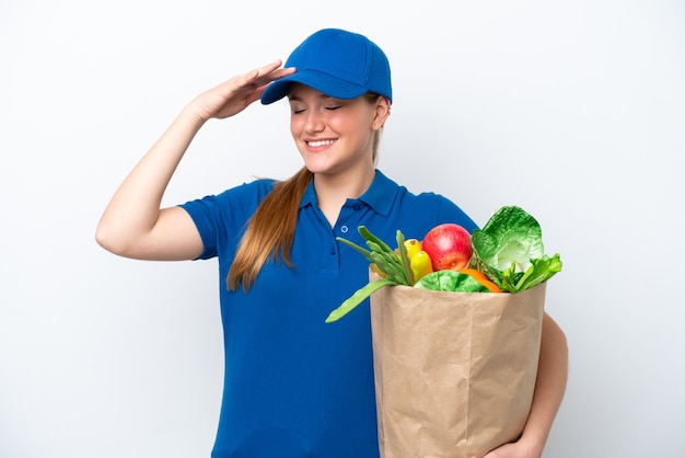 Young delivery woman taking a bag of takeaway food isolated on\
white background smiling a lot