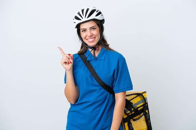 Young delivery woman with thermal backpack isolated on white background pointing to the side to present a product