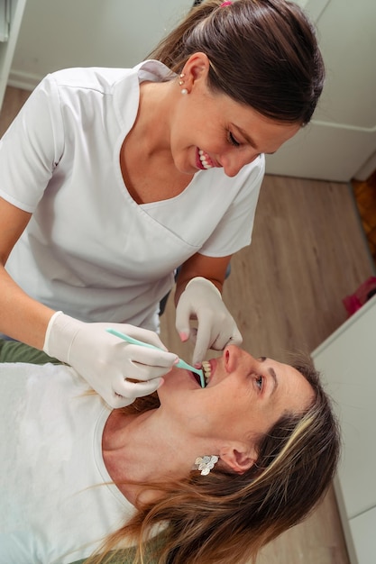 Young Dentist checking the mouth of a beautiful female patient. Concept dental care, health care.