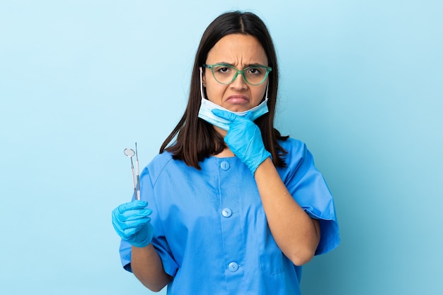 Young dentist woman holding tools