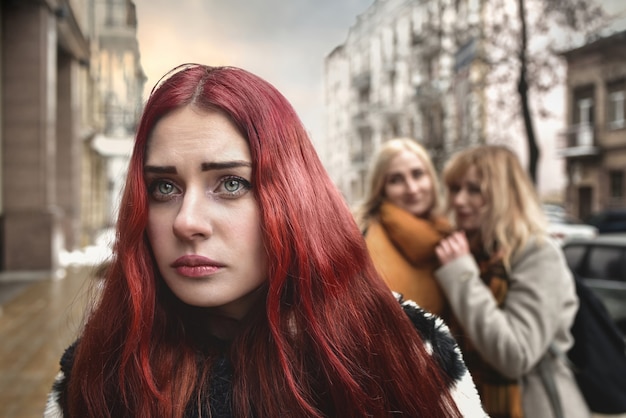 A young depressed student girl with red hair who is bullied by her teenage peers, disturbed by feelings of despair and suffering from oppression. social problems