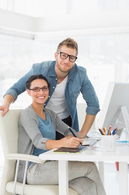 Young design team working at desk smiling at camera