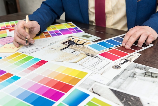 Young designer is working on a new project, choosing the perfect color for a modern apartment renovation.