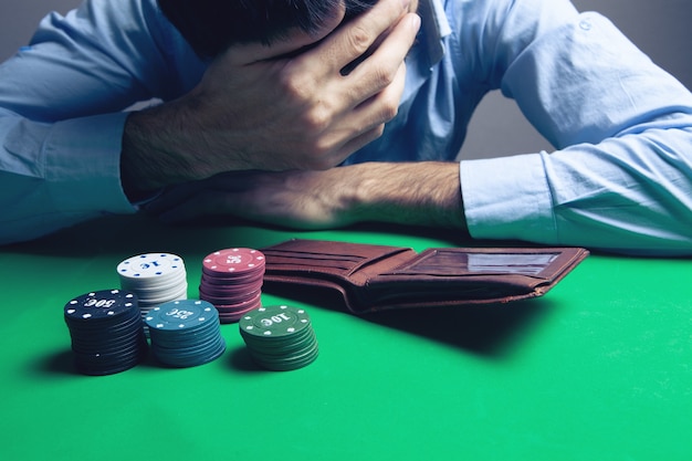 Photo young devastated businessman losing poker at casino