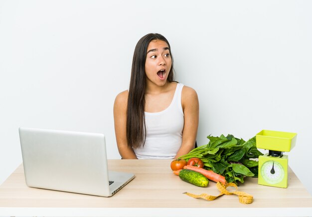 Young dietician asian woman isolated on white background being shocked because of something she has seen.