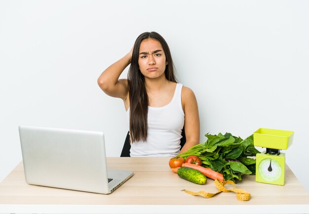 Young dietician asian woman isolated on white wall tired and very sleepy keeping hand on head