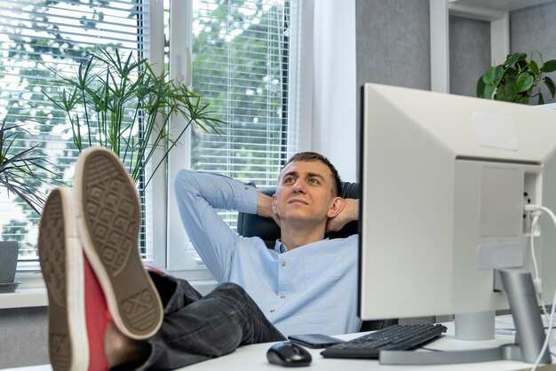 Photo young director rests in his office, putting his feet on the table. manager reflects on work.