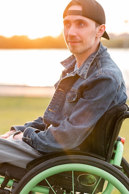 Young disabled man in wheelchair walking park high quality photo